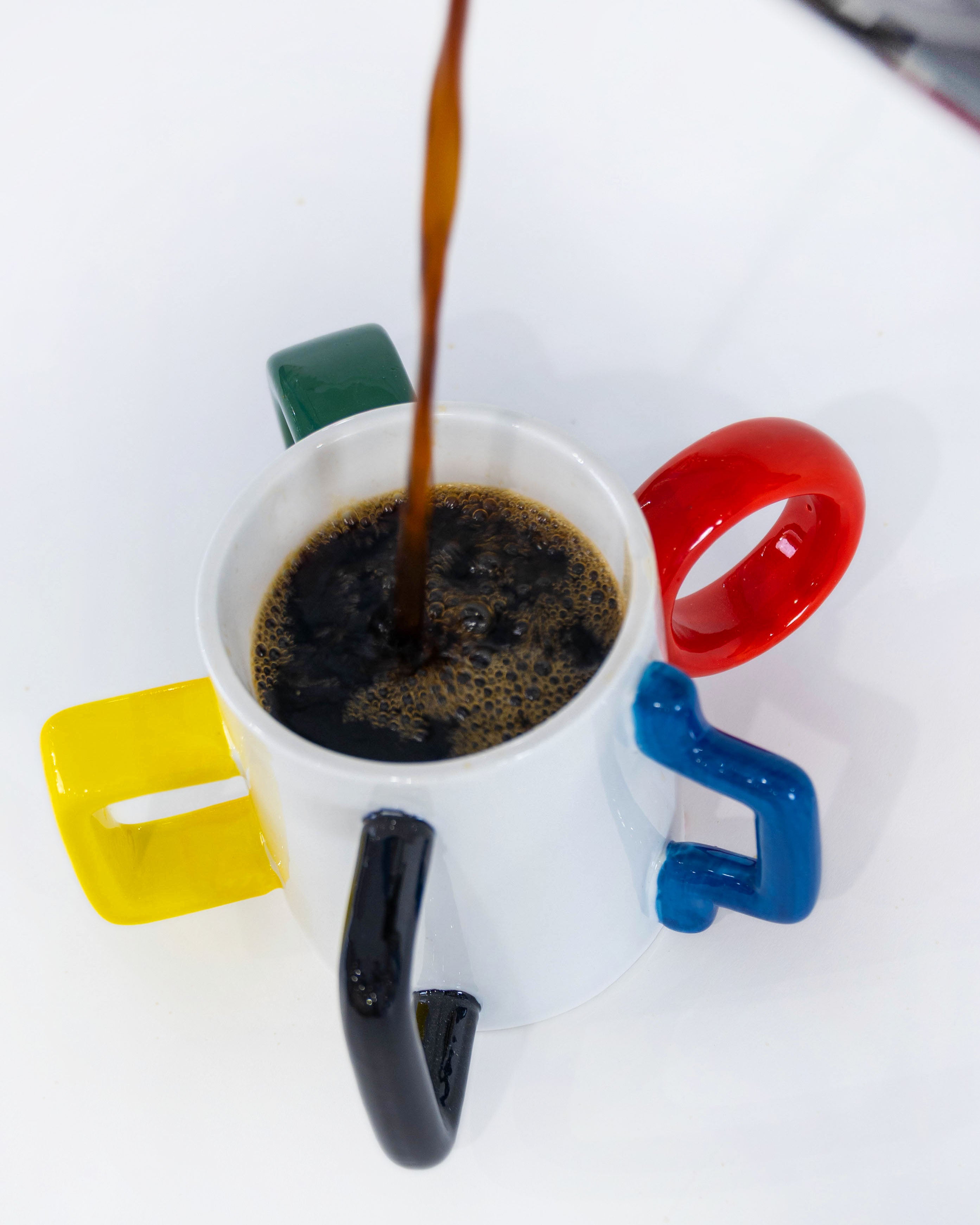 Coffee pouring into The Mood Mug with five colorful handles