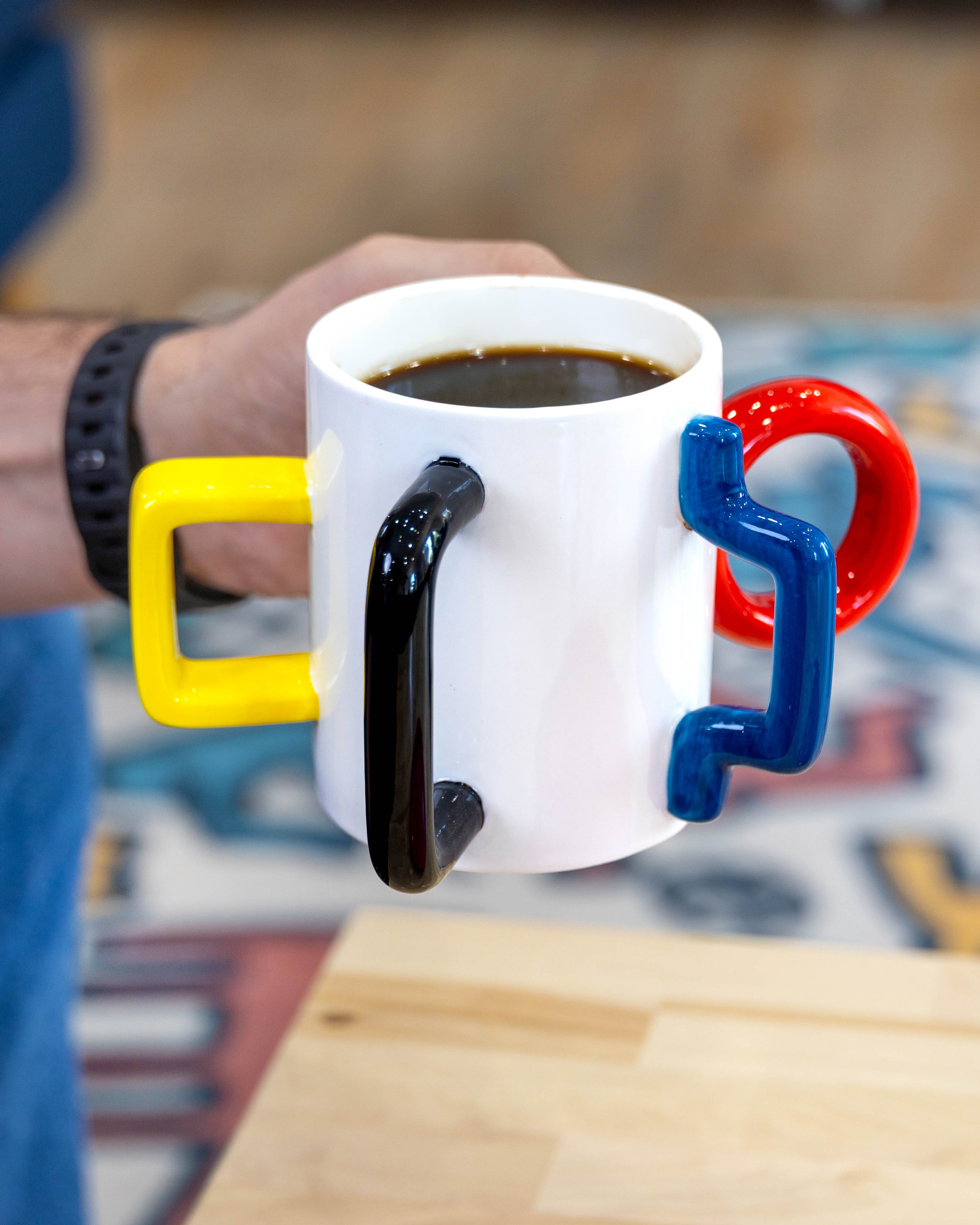 The Mood Mug filled with coffee and held by its black handle