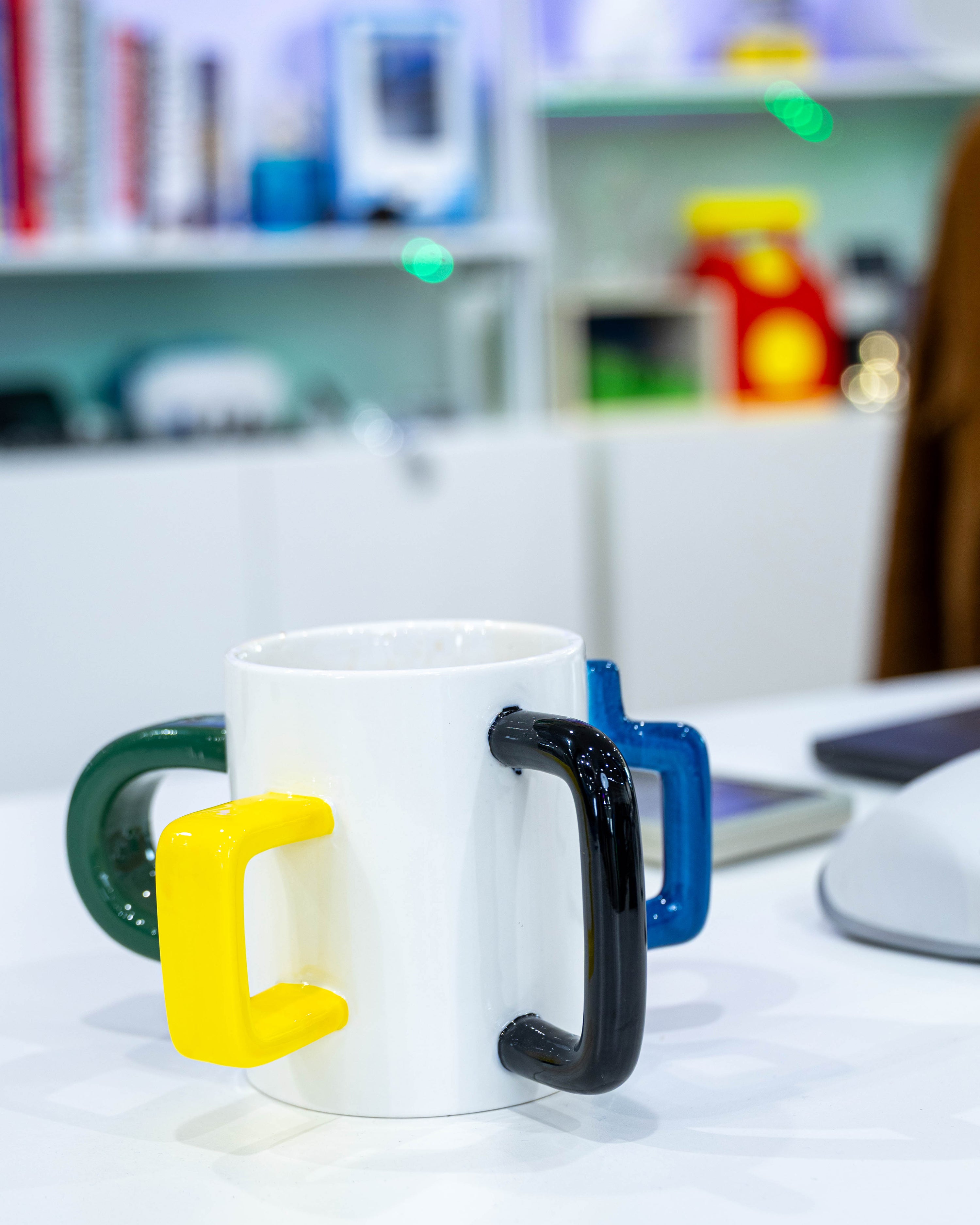 The Mood Mug on a kitchen counter with yellow, black, green and blue handles
