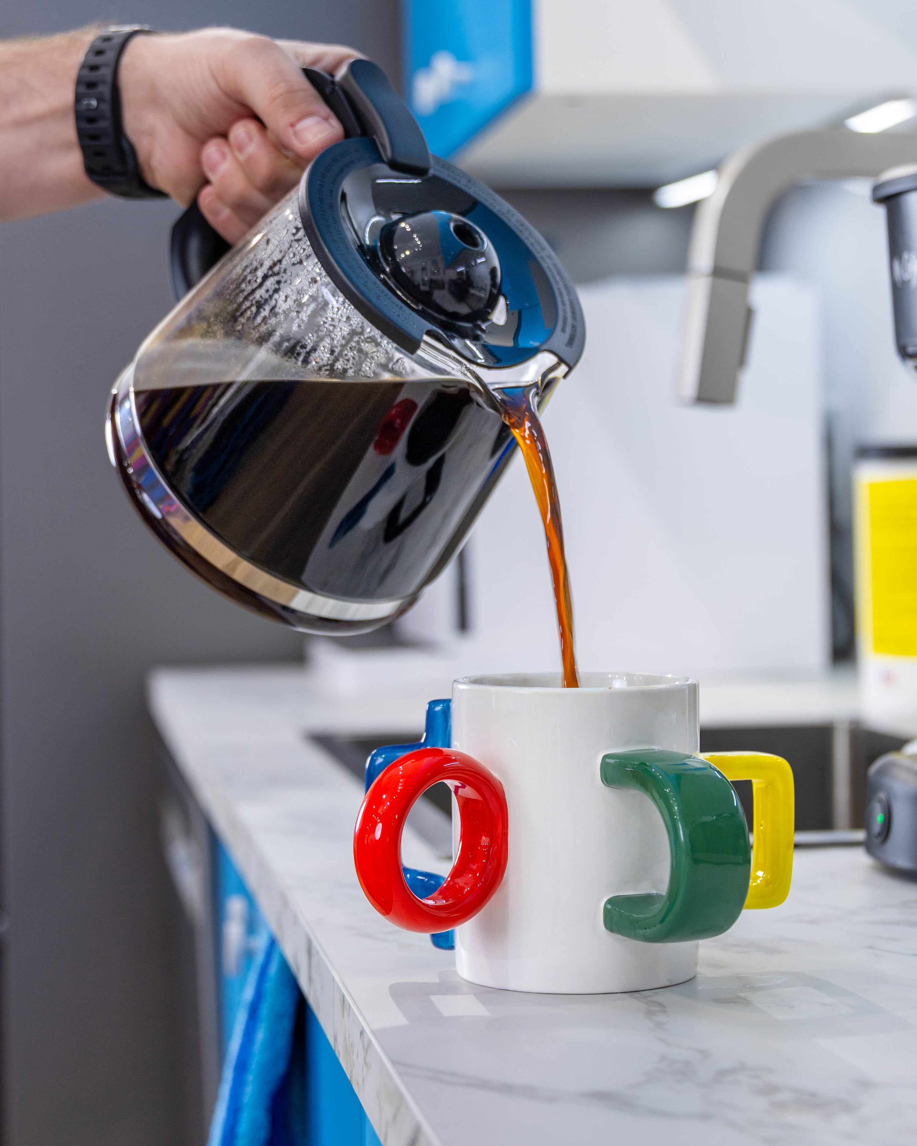 Coffee being poured from a glass carafe into The Mood Mug
