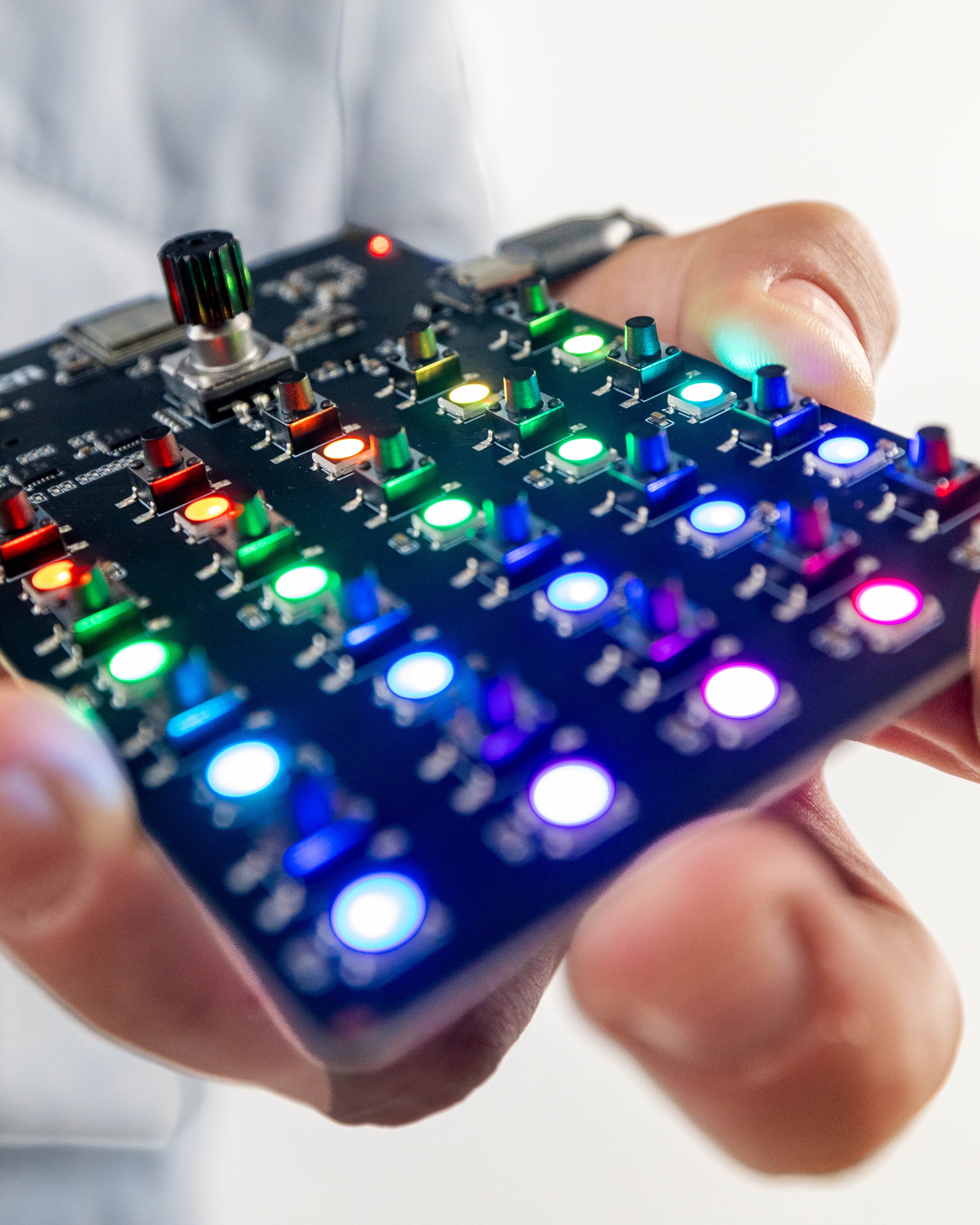 Close-up angled view of the Offscreen PCB gameboard with colorful illuminated LED buttons and rotary dial