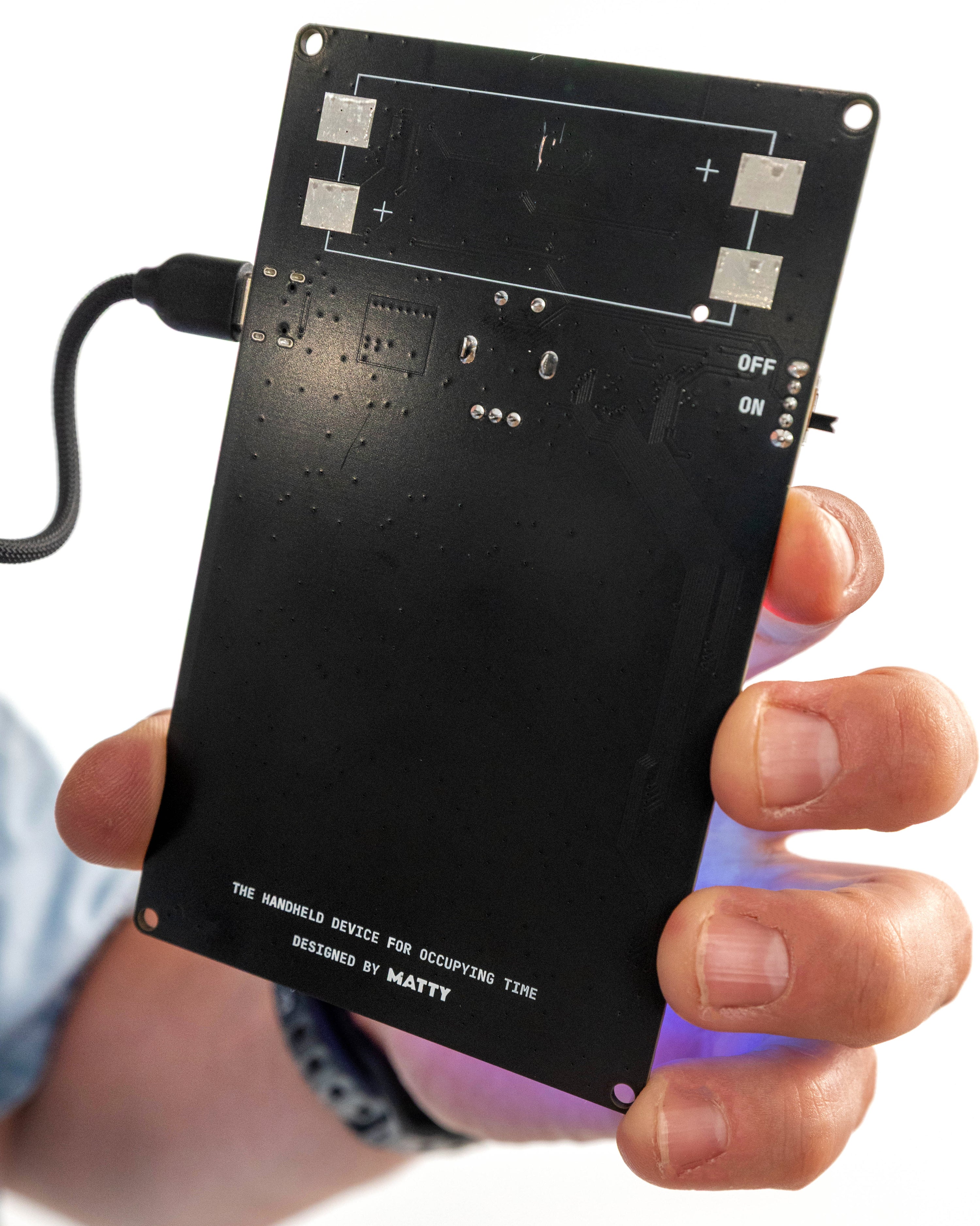 Back of the Offscreen PCB showing the on/off switch, USB-C power cable, and the tagline 'The handheld device for occupying time, designed by MATTY'